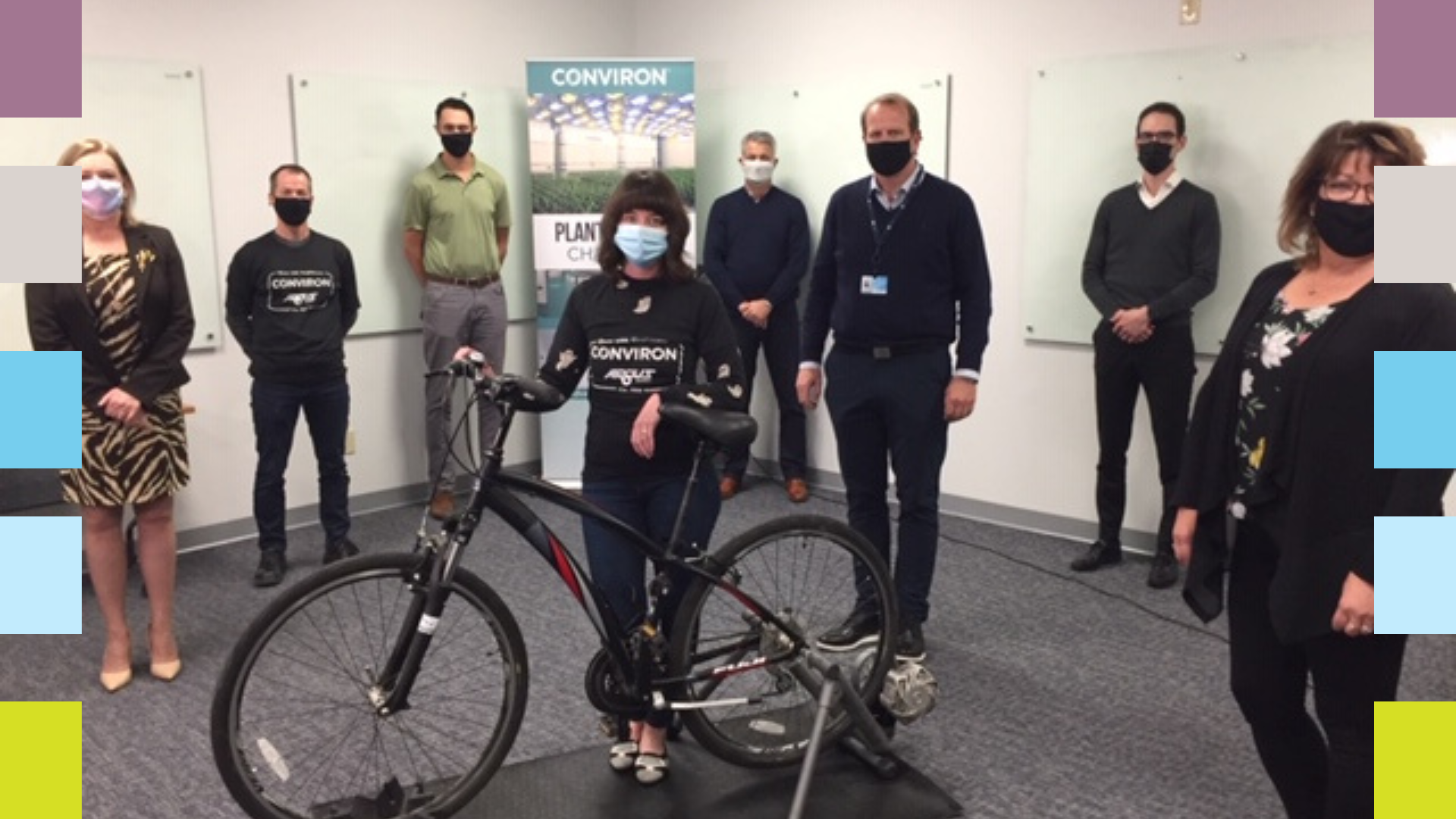Corporate team standing around bike on a trainer